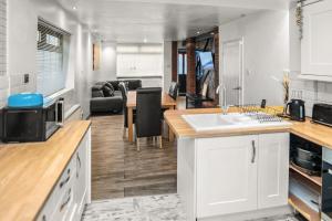 a kitchen and living room with a sink and a table at Central Manchester Family-Friendly Home with Free Parking and Workspace in Manchester
