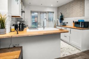 a kitchen with a sink and a counter at Central Manchester Family-Friendly Home with Free Parking and Workspace in Manchester