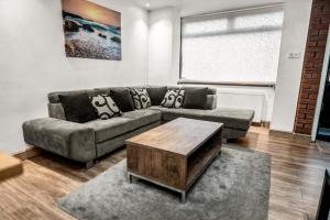a living room with a couch and a coffee table at Central Manchester Family-Friendly Home with Free Parking and Workspace in Manchester +8 photos