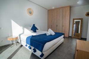 a bedroom with a bed with a blue blanket on it at Villa LaLa in Marrakesh