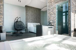 a bathtub in a room with a bedroom at Van der Valk Hotel Houten Utrecht in Houten