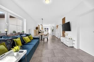 a living room with a blue couch and a kitchen at JUNIPRO Luxury Apartments in Bosen-Eckelhausen