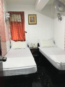 two beds in a room with a red curtain at Dutch Hostel in Hong Kong