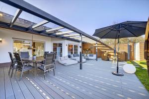 a wooden deck with a table and an umbrella at JUNIPRO Luxury Apartments in Bosen-Eckelhausen