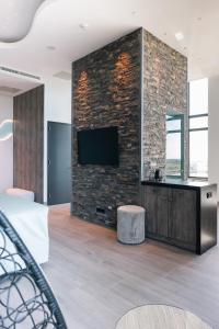 a bedroom with a brick wall with a tv on it at Van der Valk Hotel Houten Utrecht in Houten +78 photos