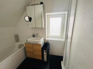 a small bathroom with a sink and a window at Schatte's kleines Appartement in Seelze in Seelze +15 photos