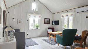 a living room with a table and chairs and windows at Two cozy accommodations near the sea SE09118 in Gåseknöde