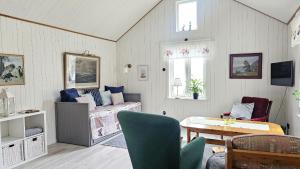 a living room with a bed and a table at Two cozy accommodations near the sea SE09118 in Gåseknöde
