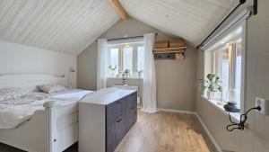 a white bedroom with a bed and windows at Two cozy accommodations near the sea SE09118 in Gåseknöde