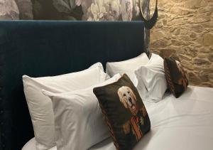 a bed with white pillows and a blue head board at Hospedium Hotel Barómetro de Camariñas in Camariñas