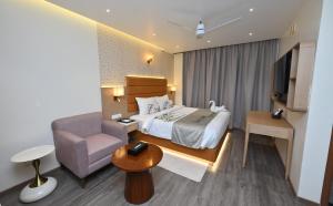 a hotel room with a bed and a chair at The Park Inn in Jhārsuguda +22 photos
