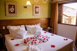 a bedroom with a bed with red roses on it at Hotel Dom Otto in Vespasiano +48 photos