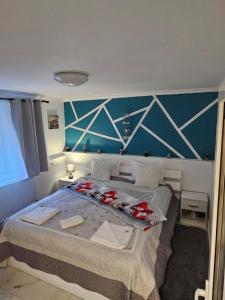 a bedroom with a large bed with a blue wall at Studio Superior Iris in Baile Felix