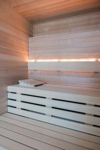 a sauna with a wooden wall and lights on it at Van der Valk Hotel Houten Utrecht in Houten