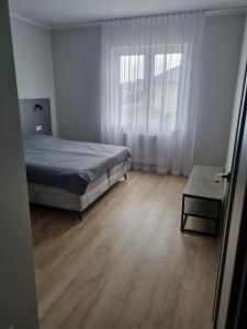a bedroom with a bed and a wooden floor at Apartament Marzeń 13 parter in Kostrzyn nad Odrą