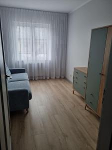 a bedroom with a bed and a dresser and a window at Apartament Marzeń 13 parter in Kostrzyn nad Odrą +2 photos
