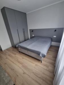 a bedroom with a bed and a wooden floor at Apartament Marzeń 13 parter in Kostrzyn nad Odrą