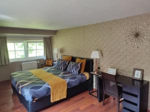 a bedroom with a bed and a desk in it at Le Manoir De Morimont in Céroux-Mousty
