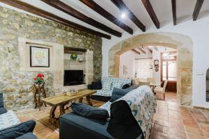 a living room filled with furniture and a stone wall at Calvario Townhouse by rentavillamallorca in Pollença