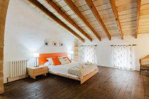 a bedroom with a large bed and a wooden ceiling at Calvario Townhouse by rentavillamallorca in Pollença +28 photos