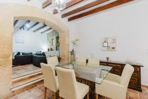 a dining room and living room with a table and chairs at Calvario Townhouse by rentavillamallorca in Pollença