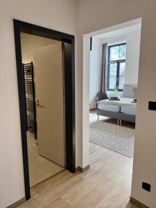 a room with a door and a living room with a couch at Penzion Klas in Měřín