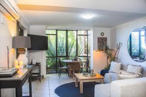 a living room with a couch and a table at The Milkwood House in Wilderness