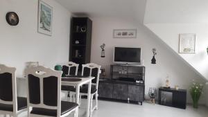 a living room with a table and chairs and a television at Schatte's kleines Appartement in Seelze in Seelze