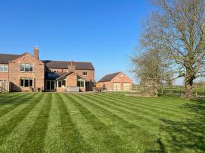 a large lawn in front of a house at Welcome To Wrexham - Hot Tub Luxury 5 bed House in Holt