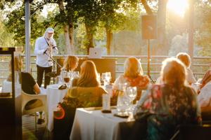 a man playing a saxophone in a restaurant with people at GMP Clubhotel Apartments in Otepää