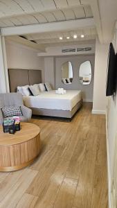 a bedroom with a bed and a couch and a table at 4U Suites in Granada