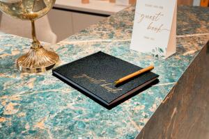 a notebook with a pen on top of a counter at Stars Hotel in Jelah