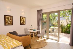 a bedroom with a bed and a table and a patio at ocean10 Guesthouse in Cape Town