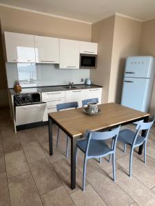 a kitchen with a wooden table and blue chairs at Villa dei Roveri in Tignale