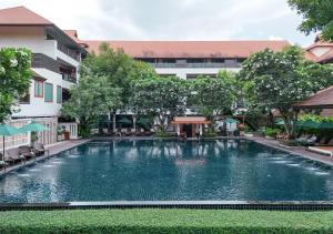 a large swimming pool in front of a building at RatiLanna Riverside Spa Resort in Chiang Mai