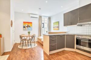 a kitchen and dining room with a table and chairs at Heimby - Studio w Free parking in Bergen