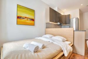 a bedroom with a large bed with towels on it at Heimby - Studio w Free parking in Bergen +14 photos