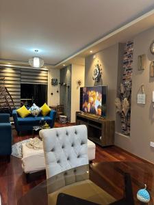 a living room with a couch and a tv at Departamento de lujo domotizado en la mejor zona de Cochabamba, frente al Paseo Aranjuez in Cochabamba