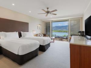 a hotel room with two beds and a television at Pullman Reef Hotel Casino in Cairns