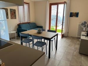 a kitchen and living room with a table and chairs at Villa dei Roveri in Tignale