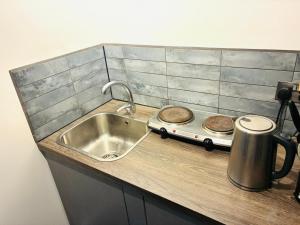 a kitchen counter with a sink and a stove at 26 Station Way in Cheam