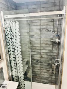 a shower with a glass door in a bathroom at 26 Station Way in Cheam