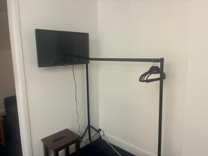 a black stand with a flat screen tv on a wall at 26 Station Way in Cheam