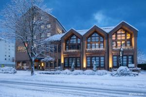 a large building with snow on the ground at Leine Hotel in Pattensen