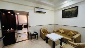 a waiting room with a couch and a table at Aadhar Hotel in Gurgaon +10 photos