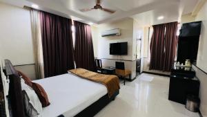 a hotel room with a bed and a television at Aadhar Hotel in Gurgaon