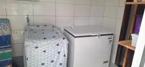 a small kitchen with a refrigerator and a table at Casa em condominio com piscina na beira do rio Alegre in Santo Amaro