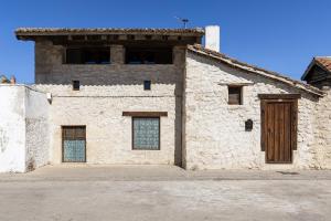 an old stone building with a wooden door at Casa Adrados Mar de Pinos con Patio y Barbacoa in Adrados
