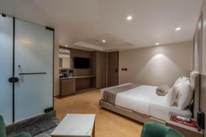 a hotel room with a bed and a tv at Hotel Shivashish in Ahmedabad