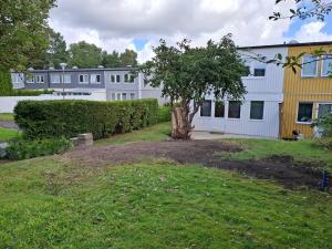 a tree in a yard in front of a building at Workers Stay - Construction Worker Housing in Gothenburg